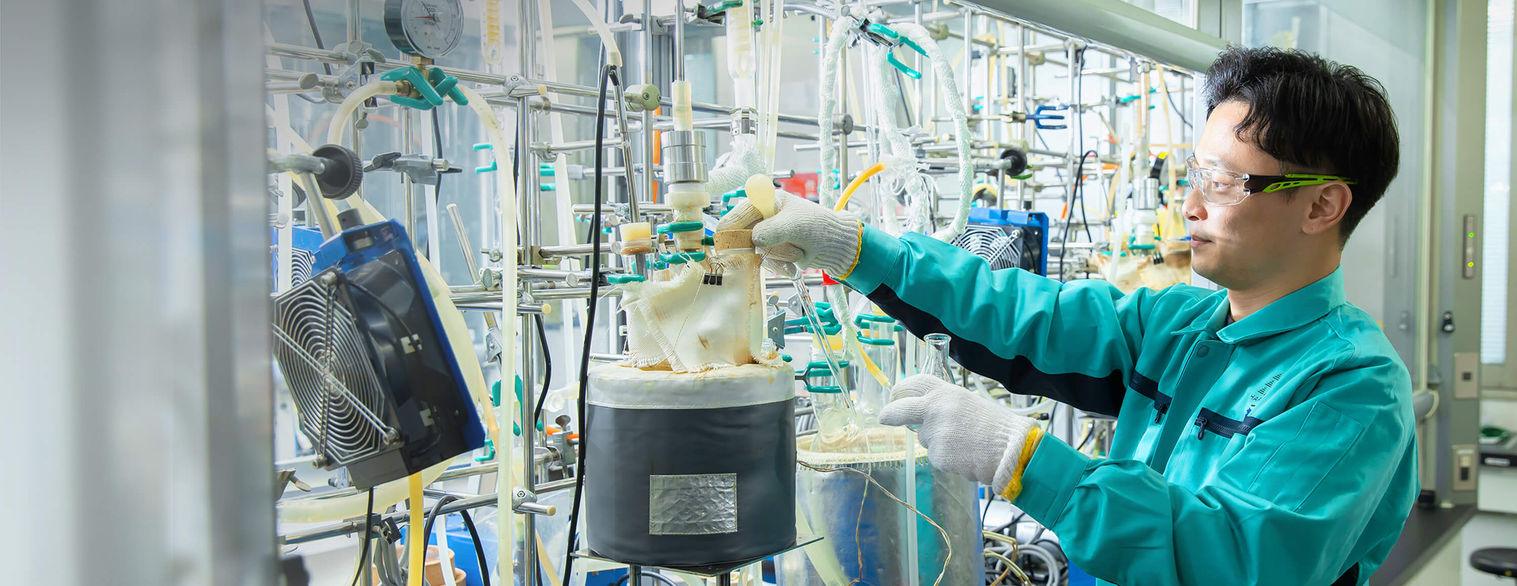 安全メガネと作業服を着た研究員